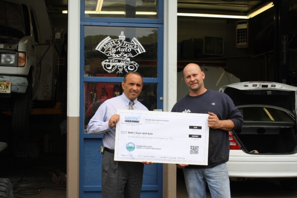 Matthew Siemientkowski (right), owner of Matt’s Truck and Auto Repair, accepts a Façade Improvement Program reimbursement check for $1,845 from Freeholder Thomas A. Arnone on Sept. 29, 2014 in Eatontown, NJ.
